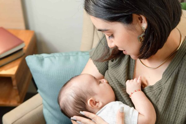 Women in green shirt holding baby in her arms